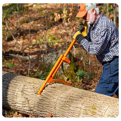 Older man wearing work gloves and a hat using an orange lever tool to roll a large fallen tree trunk in a wooded outdoor area.