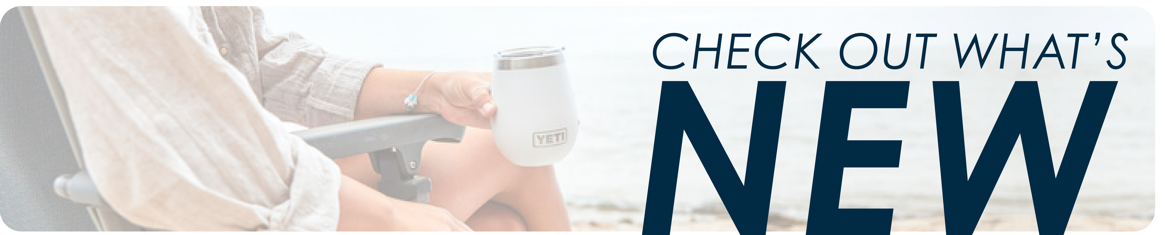 Person sitting outdoors holding a light-colored insulated drink container with text encouraging viewers to explore new items, set against a soft natural background.